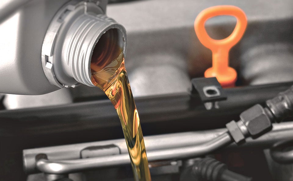 An image of oil being poured into an engine. 