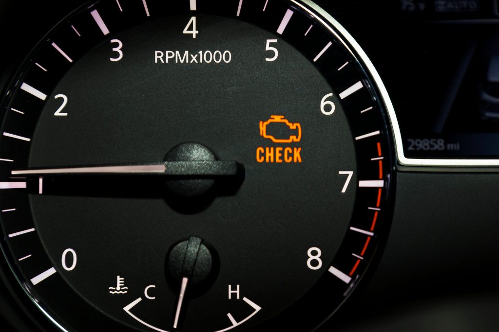 An image of an RPM gauge with the Check Engine light ignited, signifying you need auto service.