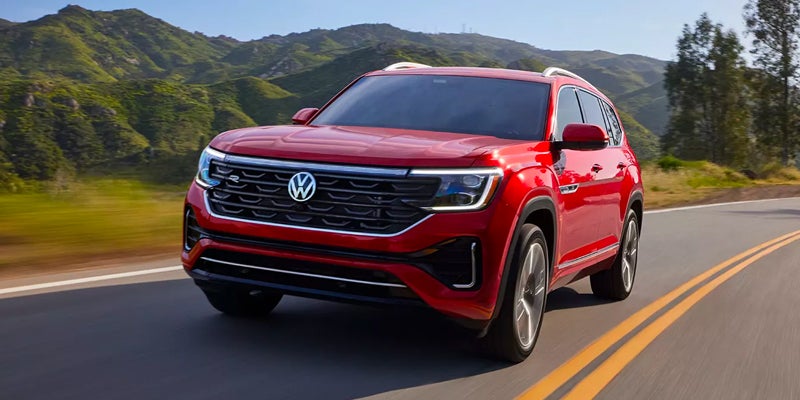 A red 2024 Volkswagen Atlas driving down the highway
