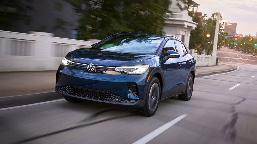 An ID.4 in Tourmaline Blue Metallic drives along a city street.